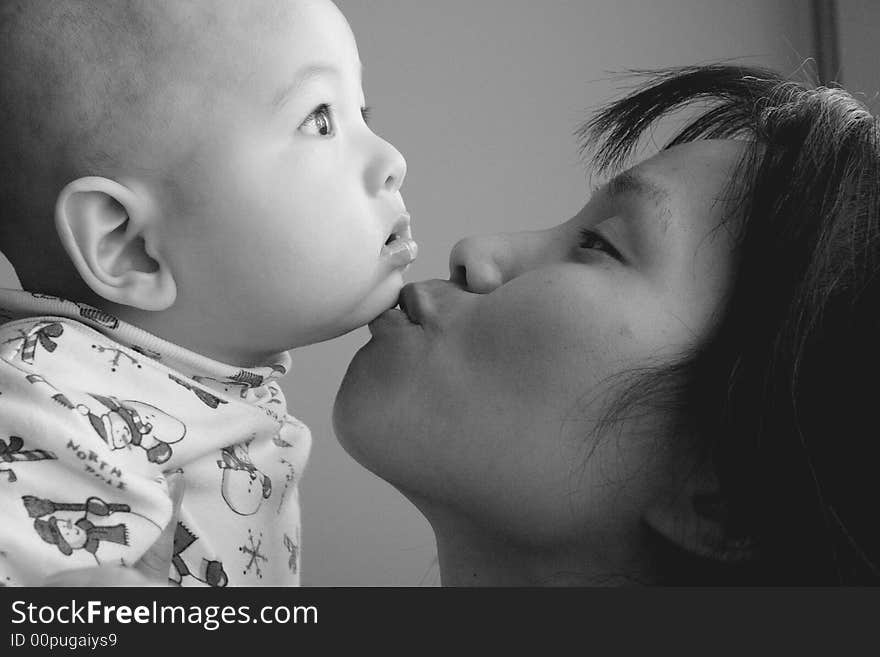 Mother kisses baby son.