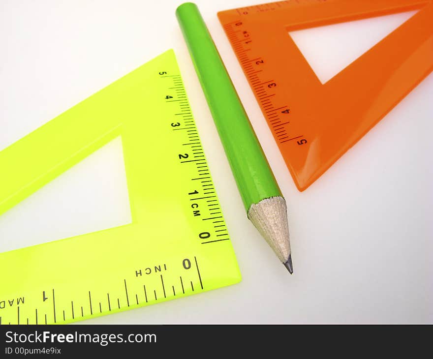 Two triangle ruler and pencil on light background