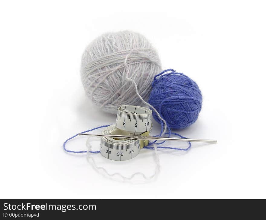 Balls of wool, tape measure and hook on a white background. Balls of wool, tape measure and hook on a white background