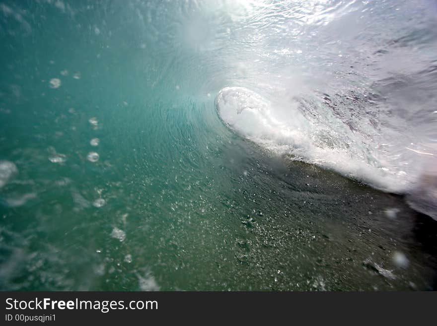 An ocean wave breaks along the shore of Hawaii. An ocean wave breaks along the shore of Hawaii.