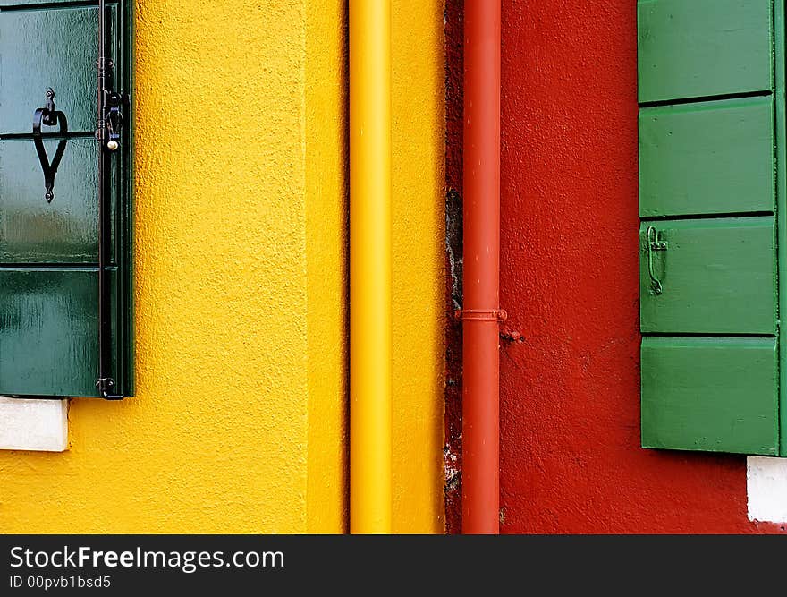 Along the water of the Venetian island Burano are multi-colored houses, painted by artists. Along the water of the Venetian island Burano are multi-colored houses, painted by artists