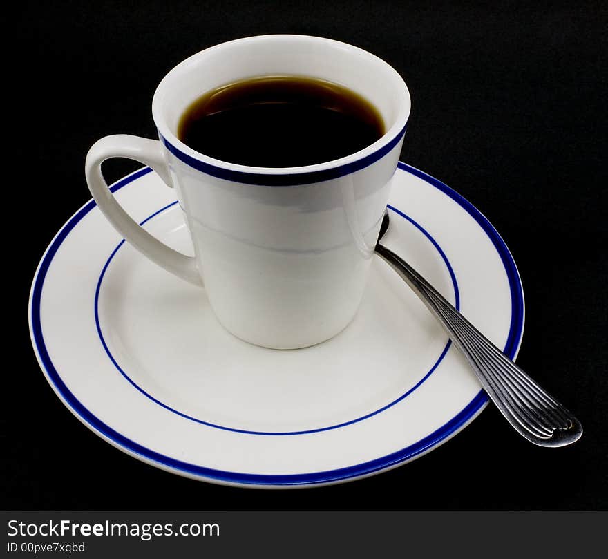 Coffee cup, saucer and spool isolated on black background.