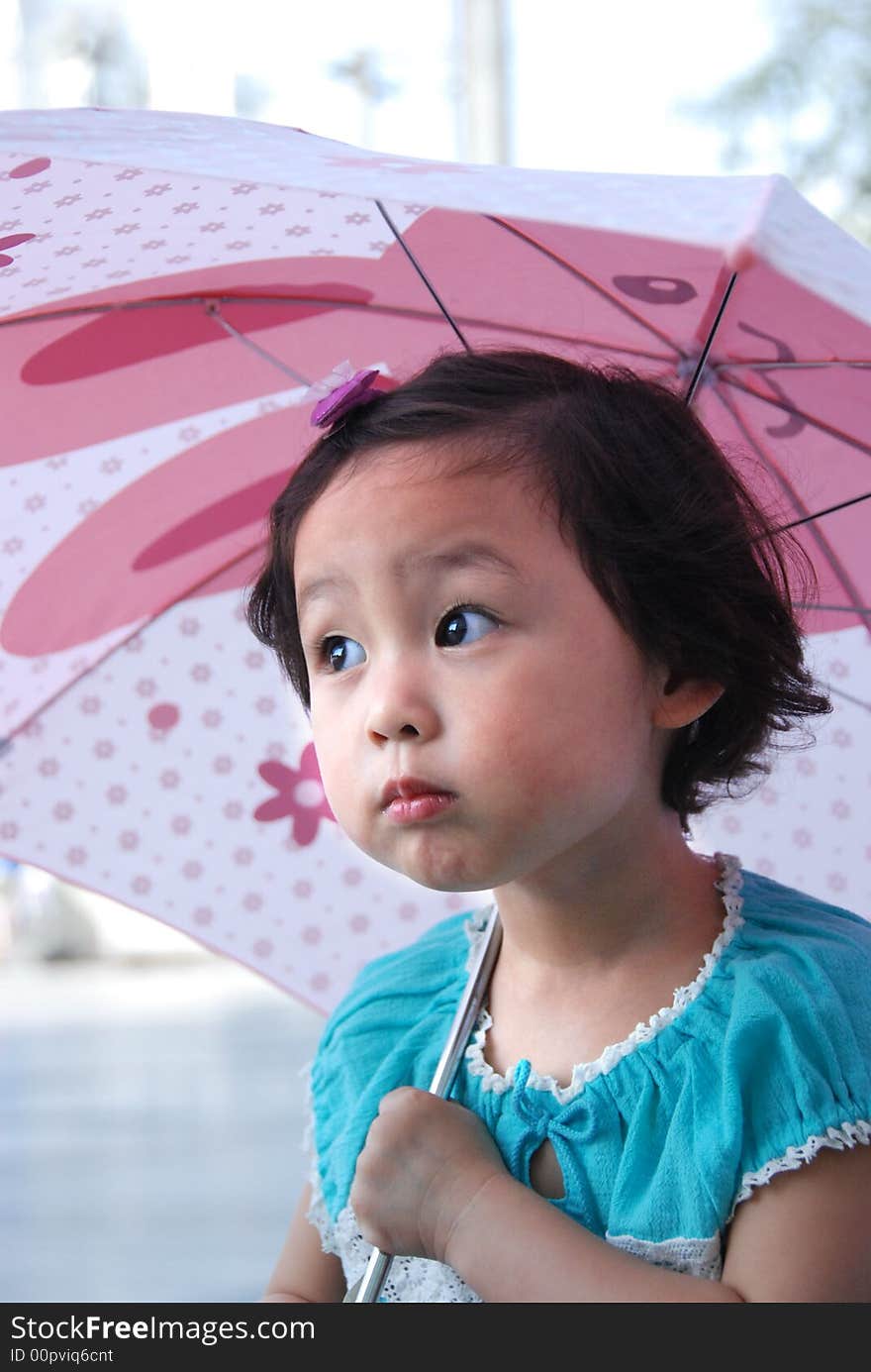 Cute beautiful Chinese young child under umbrella in summer