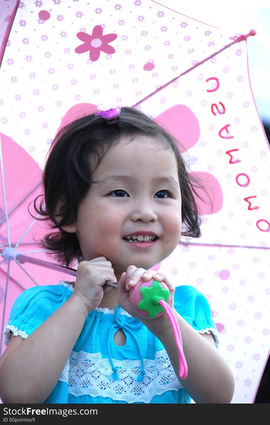 Cute beautiful Chinese young child under umbrella in summer