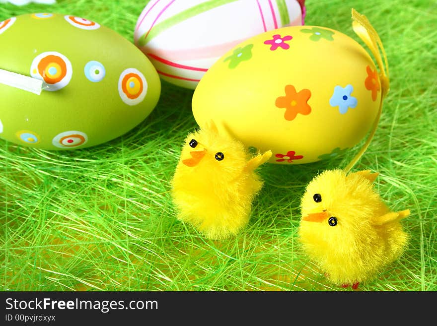 Pastel and colored Easter eggs on green