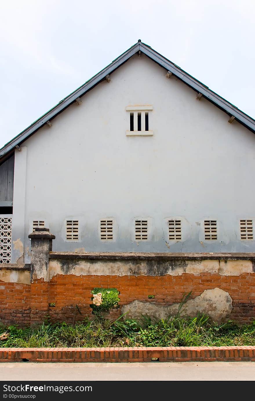 Rundown house with red brick fence