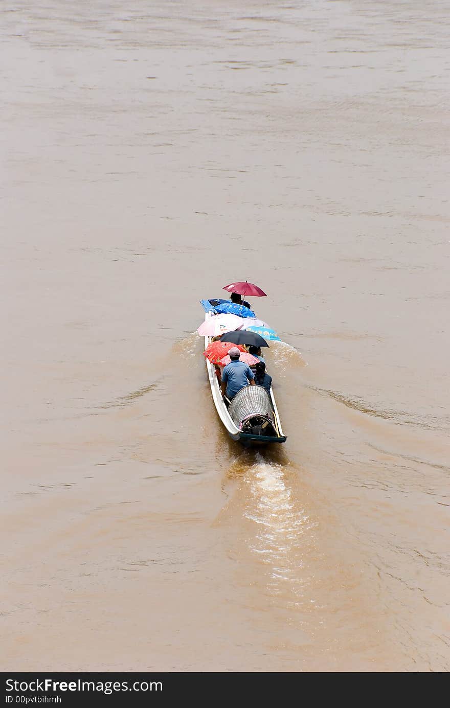 Colourful longtail boat crossing a river