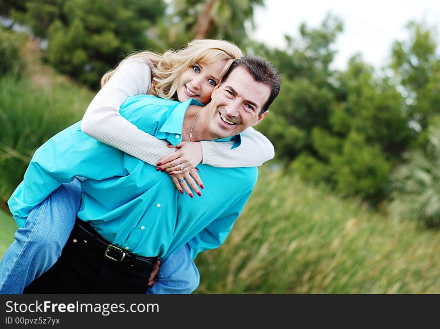 A happy couple smiling in green park environment