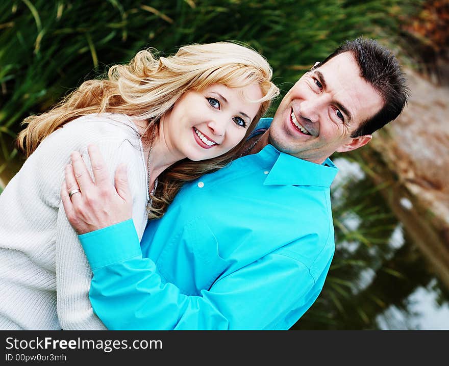 A happy couple smiling in green park environment