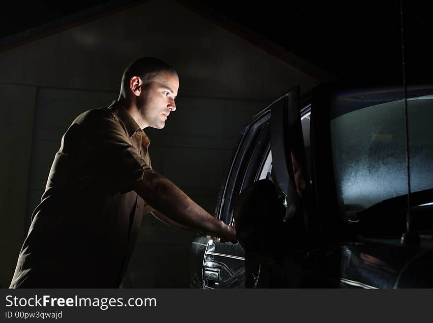 Night shot of a man looking inside a vehicle and seeing a bright light. It's unexplainable. Night shot of a man looking inside a vehicle and seeing a bright light. It's unexplainable.