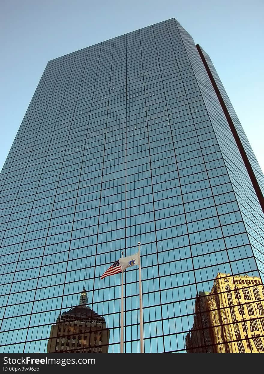 Reflection on John Hancock building with flag