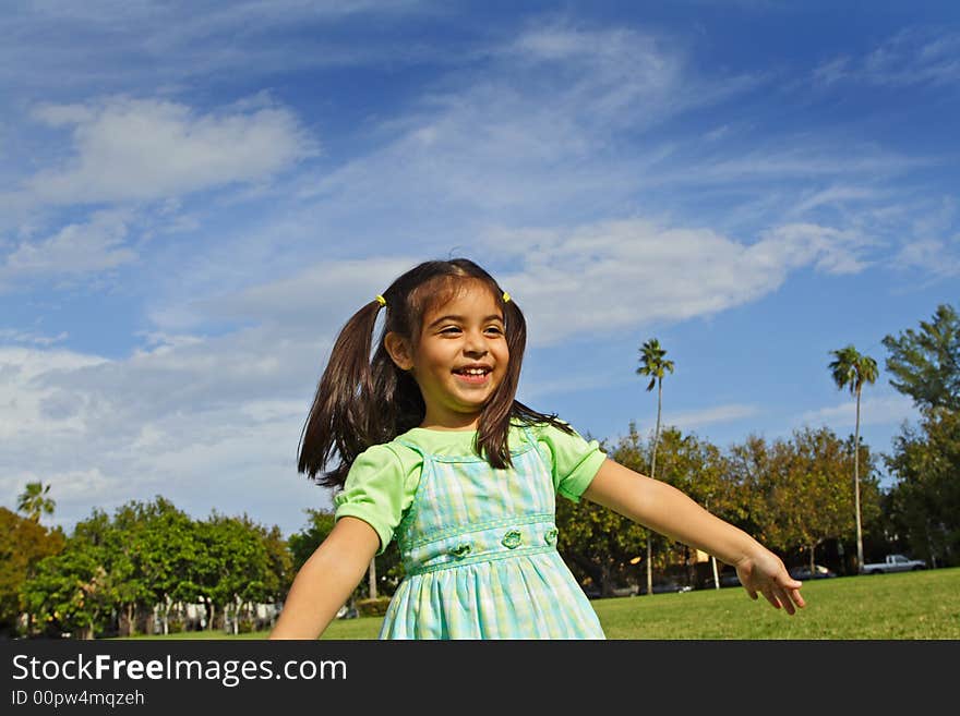 Girl in a park pretending to fly