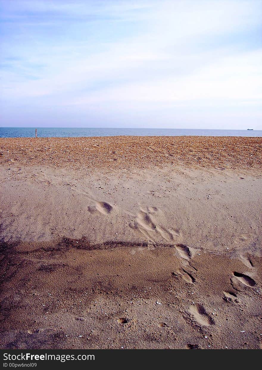 Footprints in the sand with ocean and sky in background. Footprints in the sand with ocean and sky in background