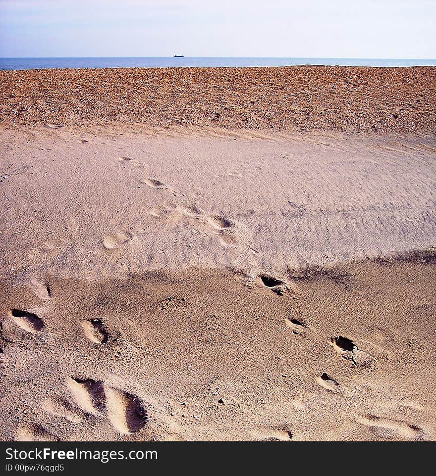 Footprints in the sand with ocean and sky in background. Footprints in the sand with ocean and sky in background