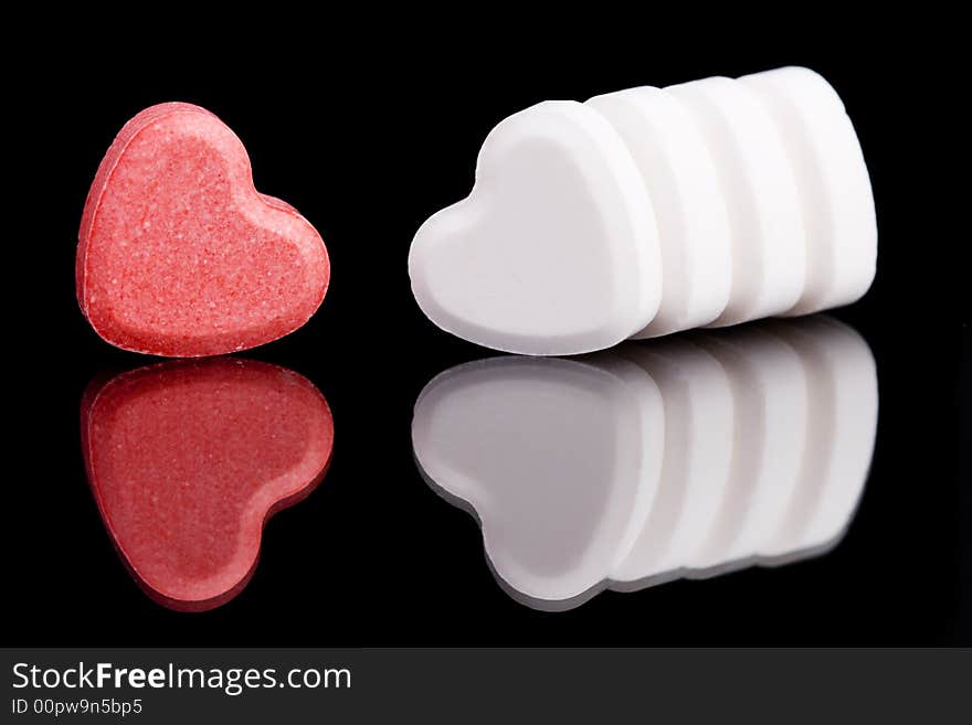 Red and white candy hearts on black background