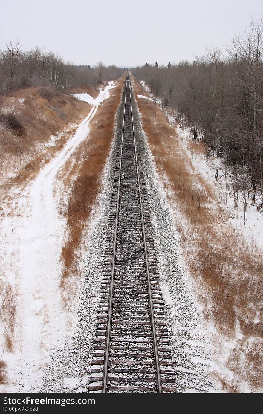 Single snow covered railroad track stretching into the distance. Single snow covered railroad track stretching into the distance