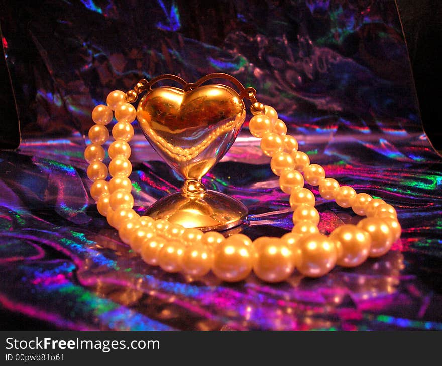 Heart and pearls on the purple background. Heart and pearls on the purple background