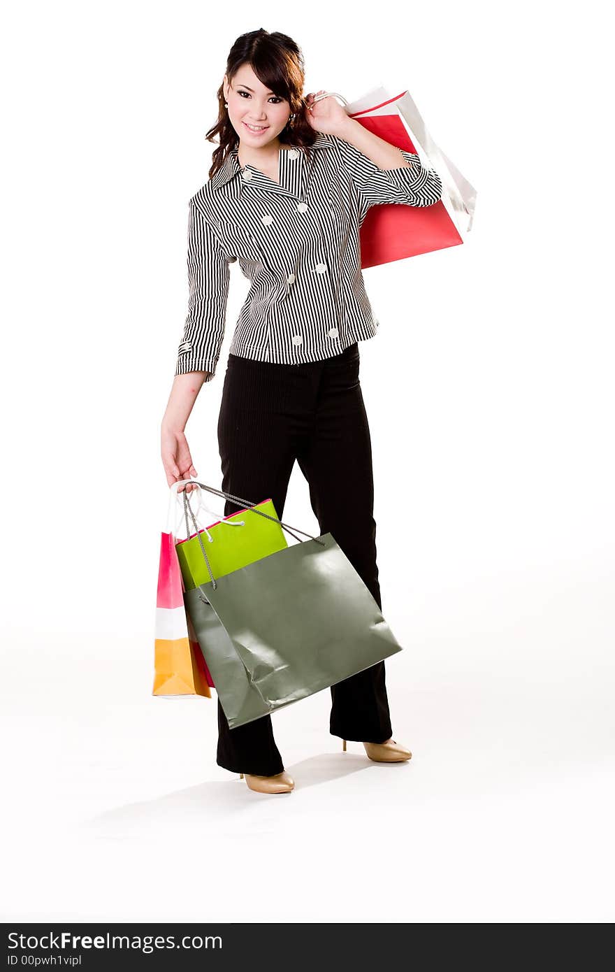 Young woman happily shopping full of paper bags. Young woman happily shopping full of paper bags