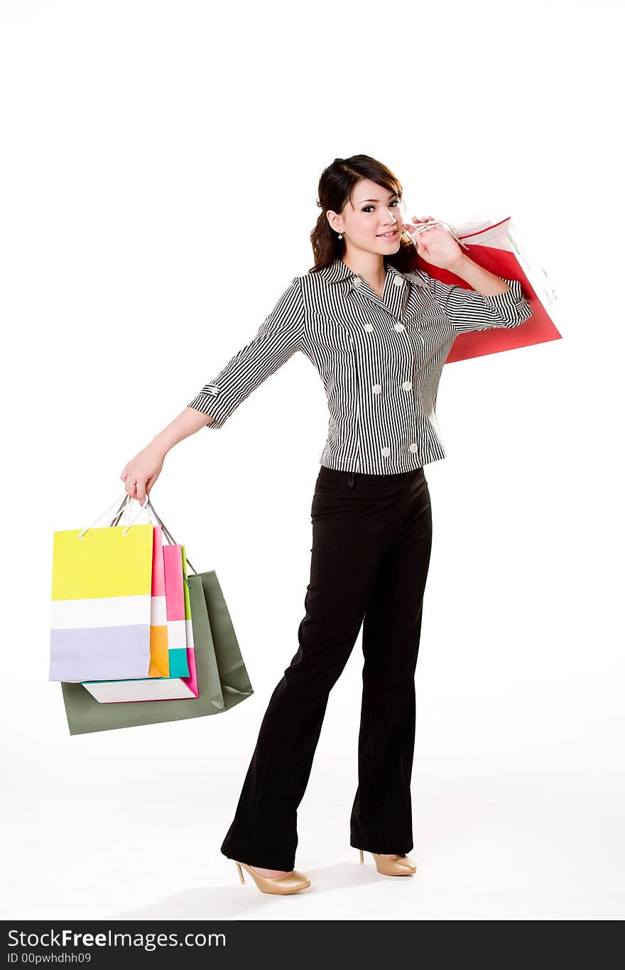 Young woman happily shopping full of paper bags. Young woman happily shopping full of paper bags