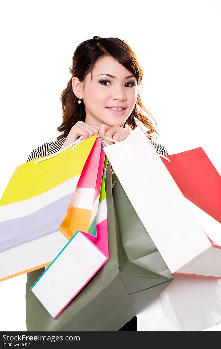 Young woman happily shopping full of paper bags. Young woman happily shopping full of paper bags