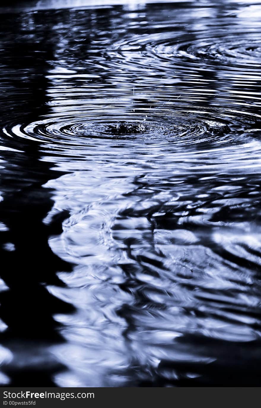 Drop rippled in dark blue water. Drop rippled in dark blue water.