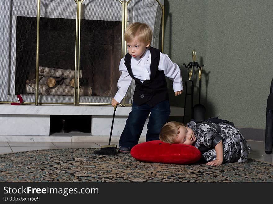 Little miss and steward. Portrait of two cute children in front of fireplace