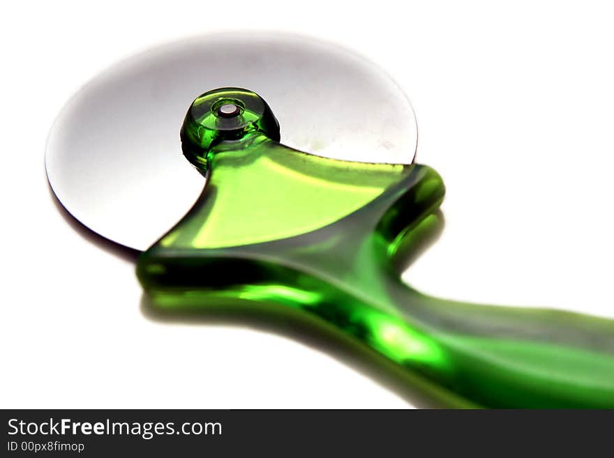 Green pizza cutter on a light background