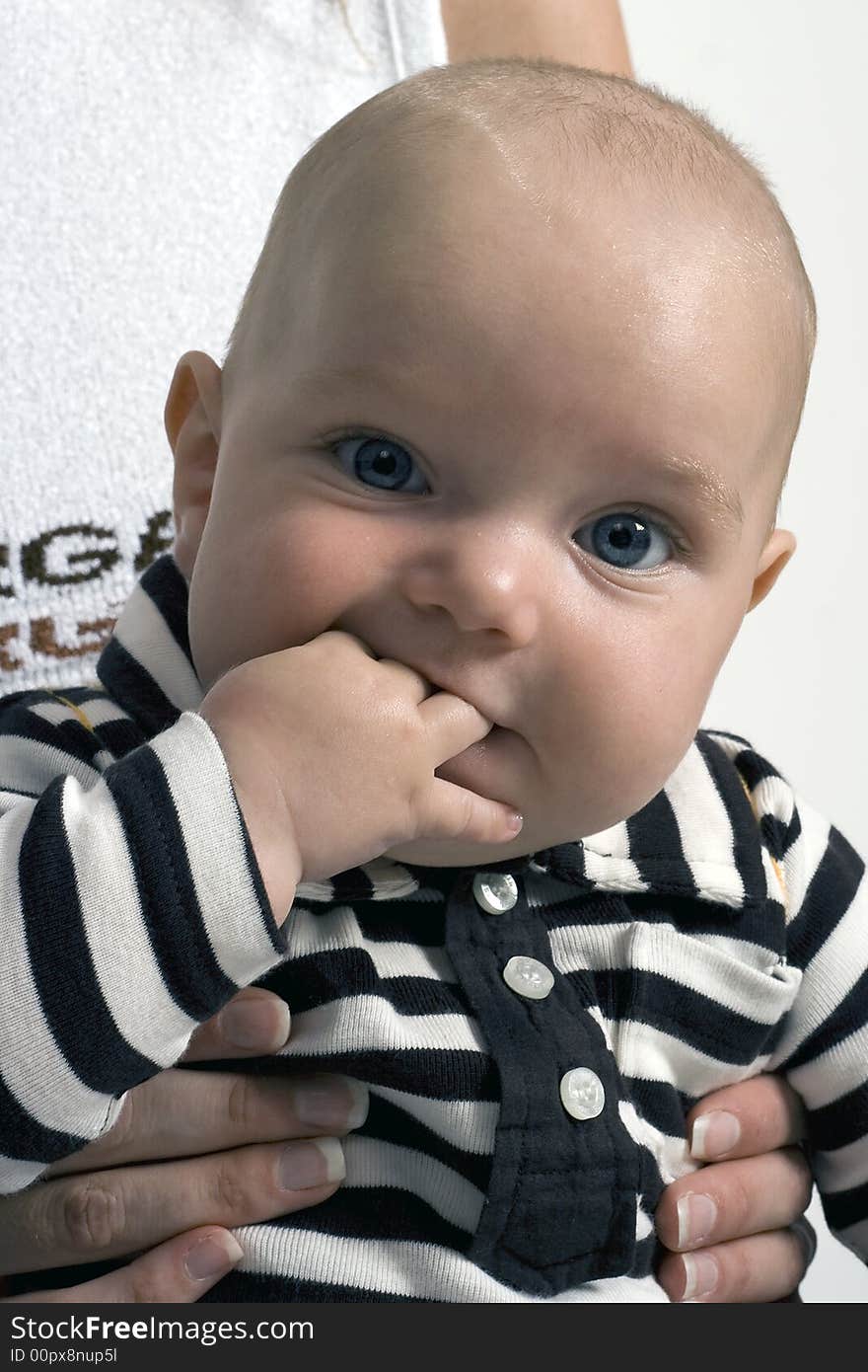 A baby that is eating his hand. A baby that is eating his hand