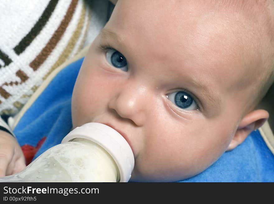 A baby that is being fed by bottle. A baby that is being fed by bottle