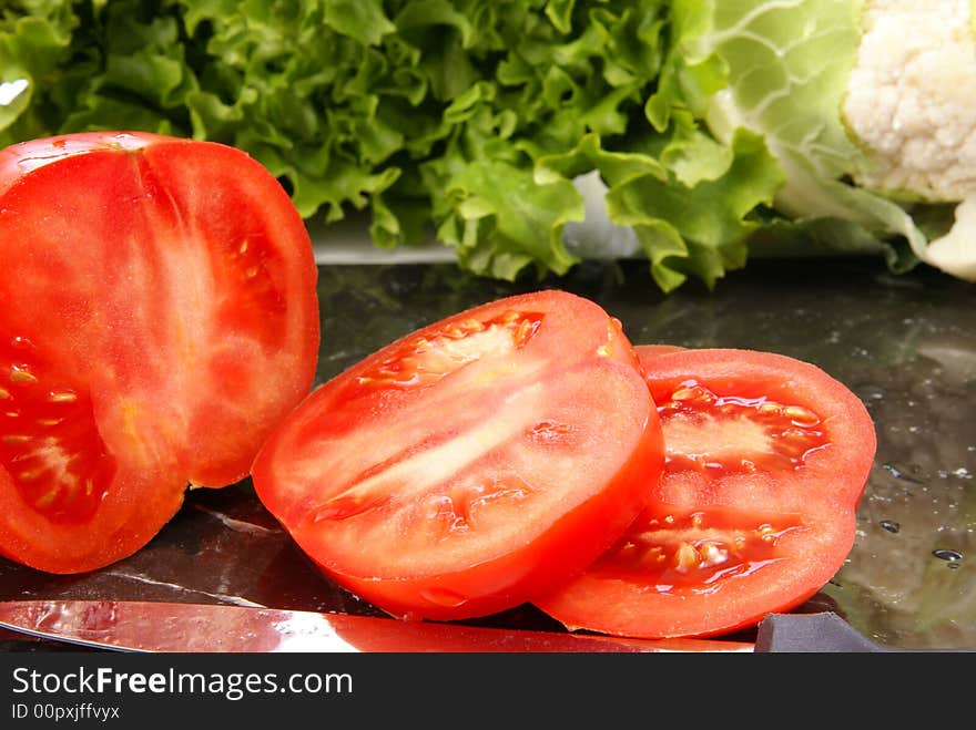 Fresh sliced ripe tomatoes on black marble cutting board. Fresh sliced ripe tomatoes on black marble cutting board.