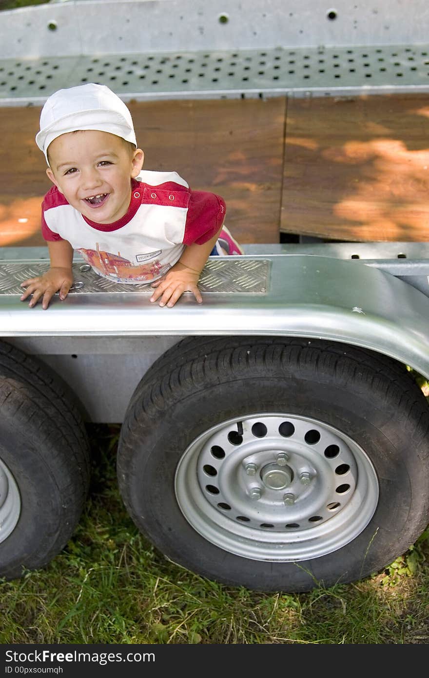 A kid playing on a huge vehicle, happy. A kid playing on a huge vehicle, happy