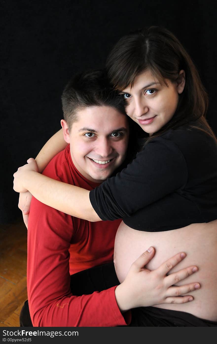 A view with a pregnant woman and her husband. Happy family. A view with a pregnant woman and her husband. Happy family