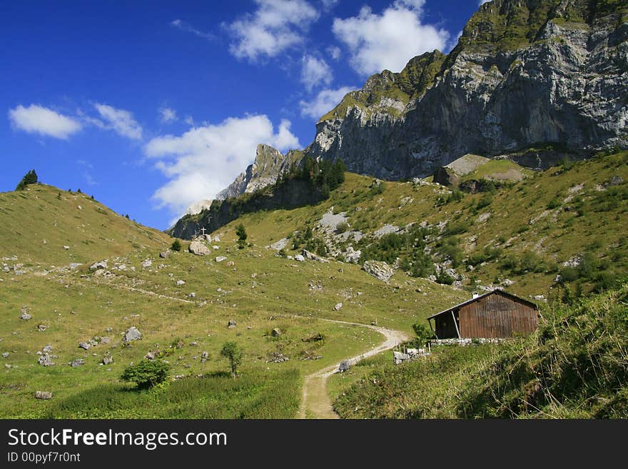 A path winds its way through a mountain pass high in the Alps. A path winds its way through a mountain pass high in the Alps