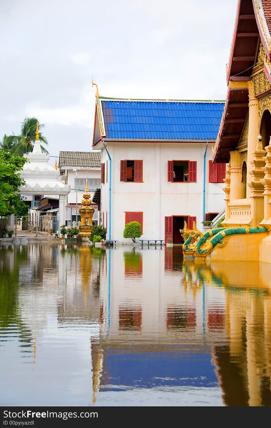 Golden flooded buddhist temple with water reflection