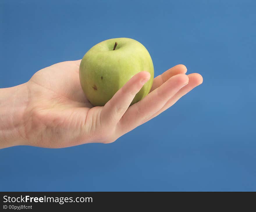 Hand to hold gpeen apple on blue background. Hand to hold gpeen apple on blue background