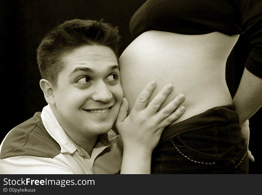 A view with a pregnant woman and her husband. Happy family. A view with a pregnant woman and her husband. Happy family