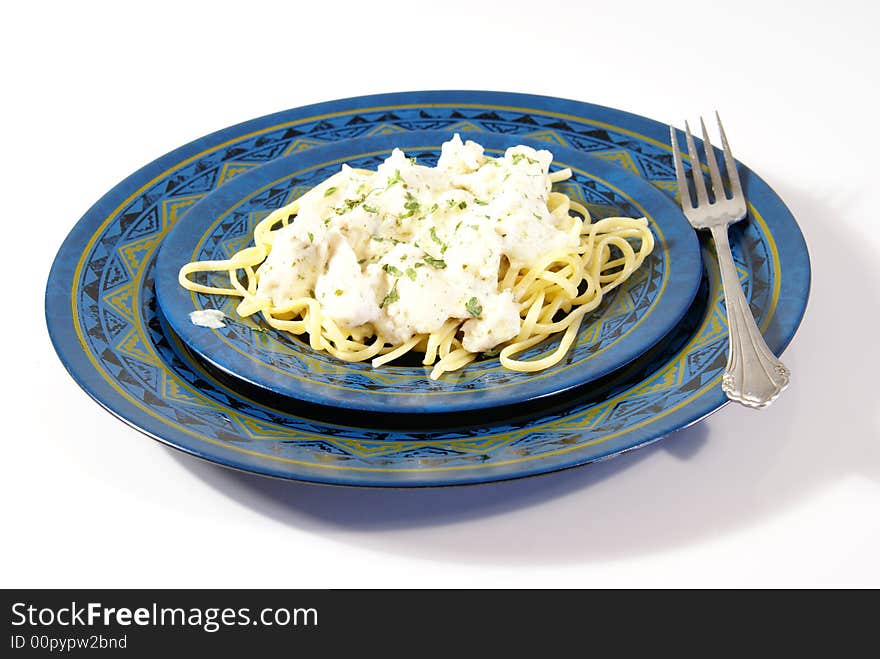 Chicken Alfredo. Sauce, chicken, and dried herbs on flat linguini pasta.