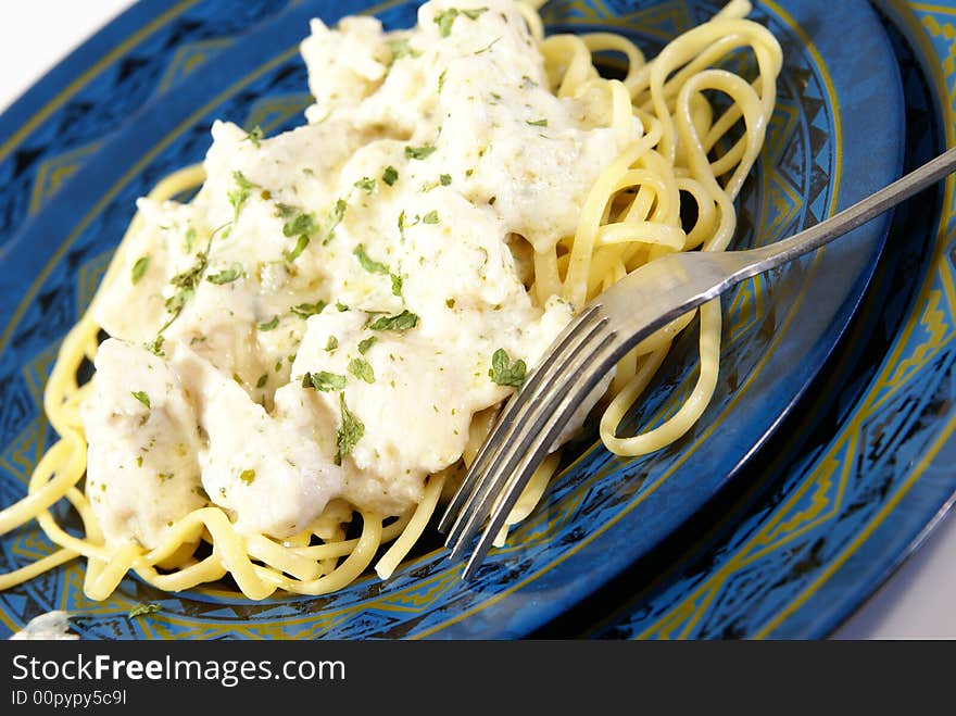 Chicken Alfredo. Sauce, chicken, and dried herbs on flat linguini pasta.