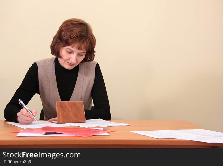 The girl sits at a table and fills in documents. The girl sits at a table and fills in documents