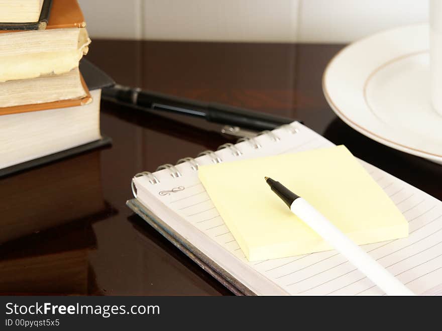 Office desk with notepads, pens, coffee and doughnuts. Office desk with notepads, pens, coffee and doughnuts