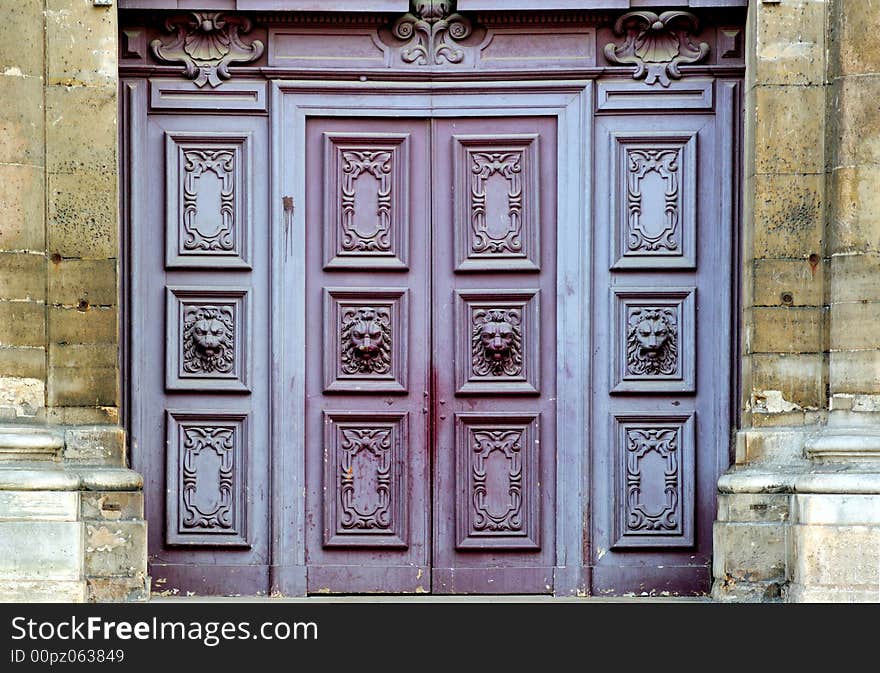 France, Paris: wooden decorated  door of st Paul church; blue door with lion heads. France, Paris: wooden decorated  door of st Paul church; blue door with lion heads