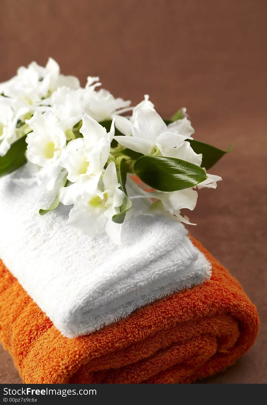 White and orange towels and orchid. White and orange towels and orchid