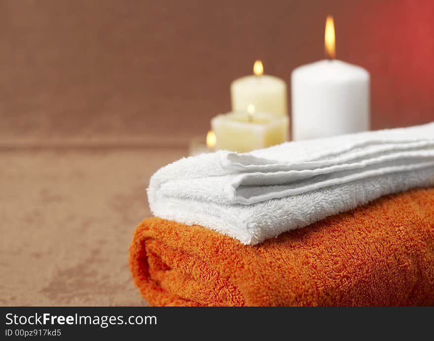 Candles and towels on brown background. Candles and towels on brown background