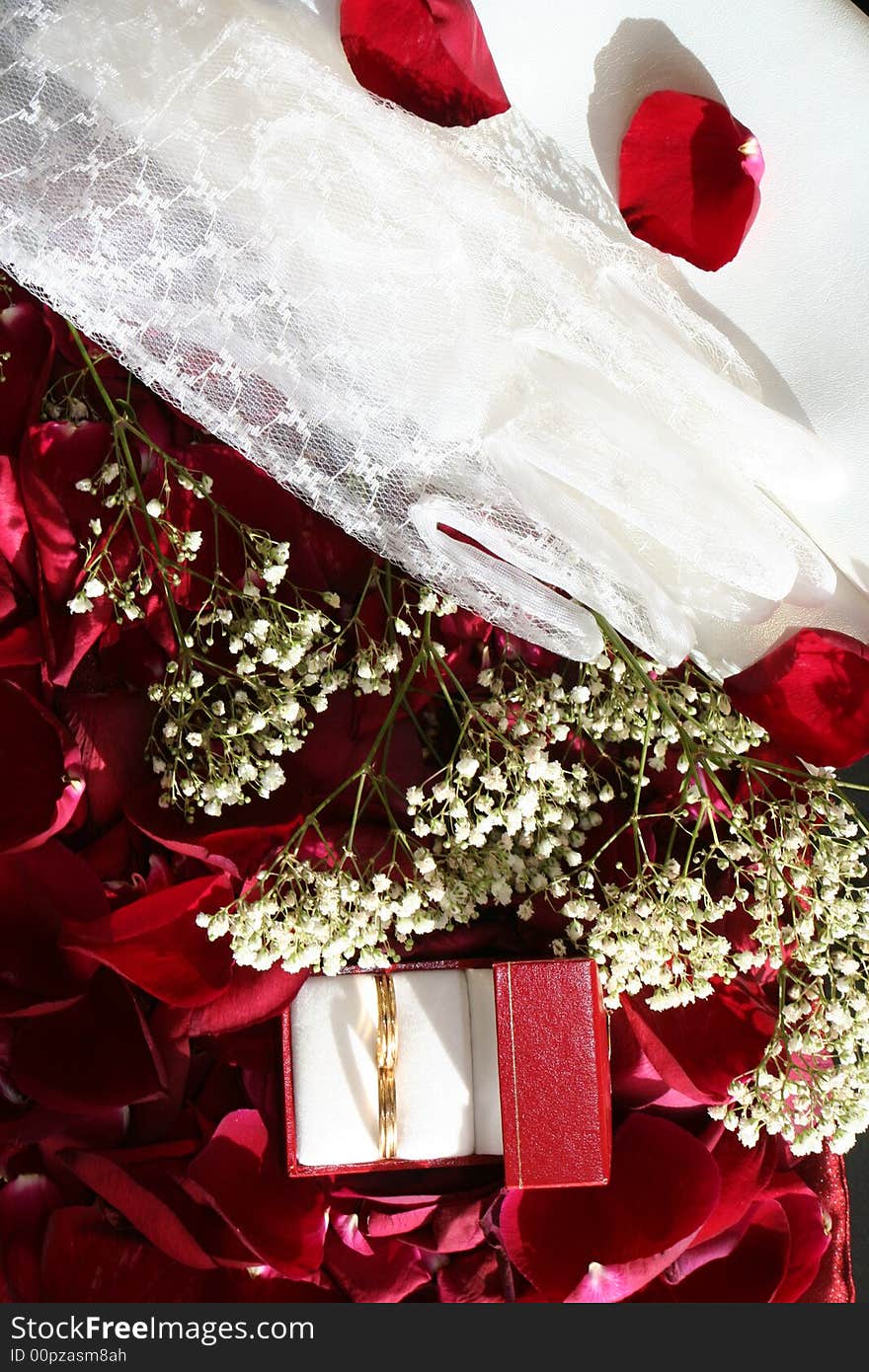 Red sunny background with wedding rings over roses petals. Red sunny background with wedding rings over roses petals