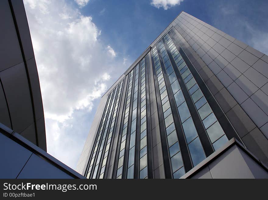 Big office building with blue sky and white clouds