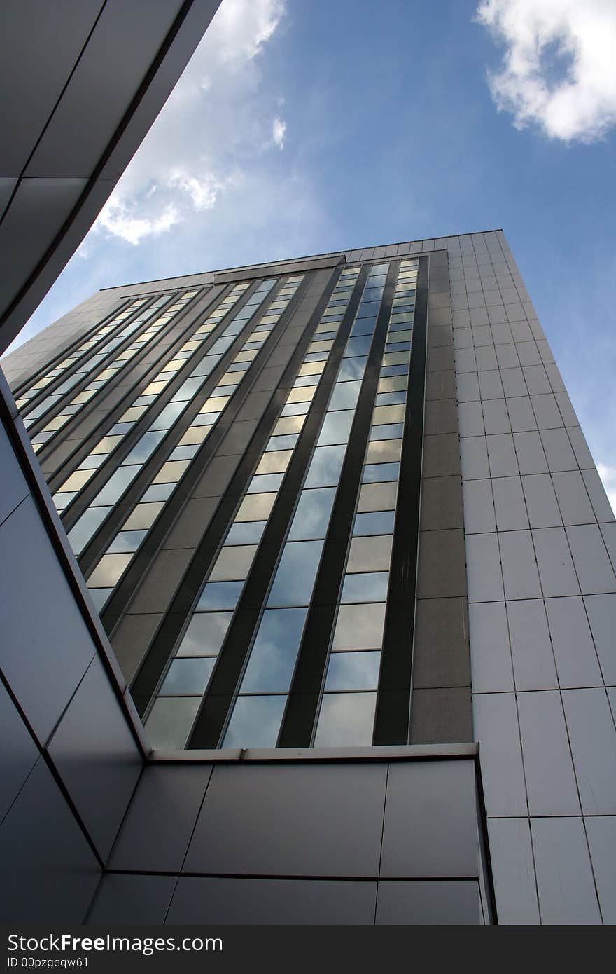 Big office building with blue sky and white clouds