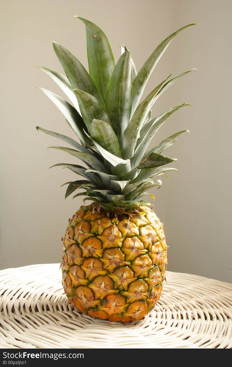 Large full pineapple on a white table. Large full pineapple on a white table