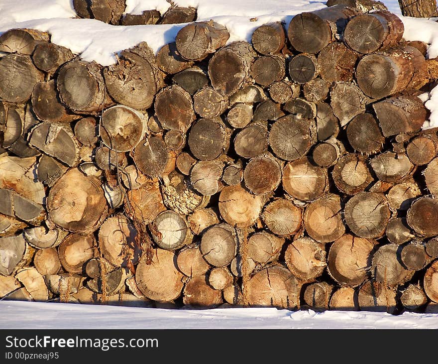 Wood logs with snow settled a top. Wood logs with snow settled a top.