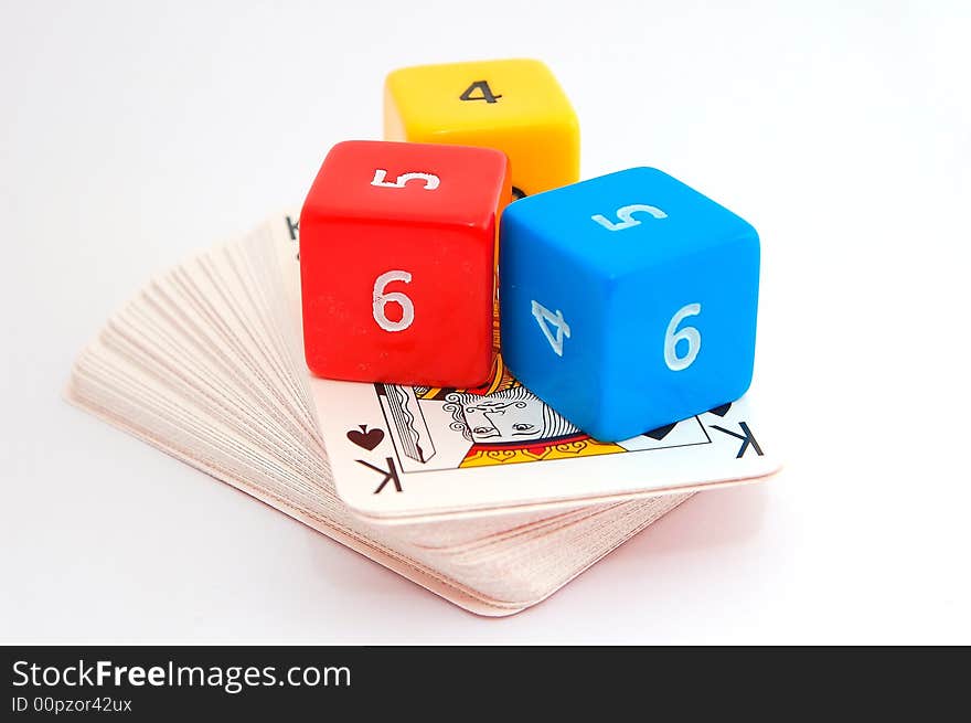 Three colorful dice on deck of cards with king of spades