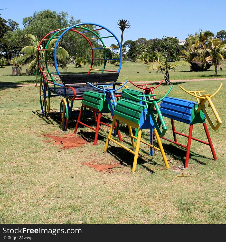 A children’s ox wagon found in a park made out of metal pipes and painted bright colours. A children’s ox wagon found in a park made out of metal pipes and painted bright colours